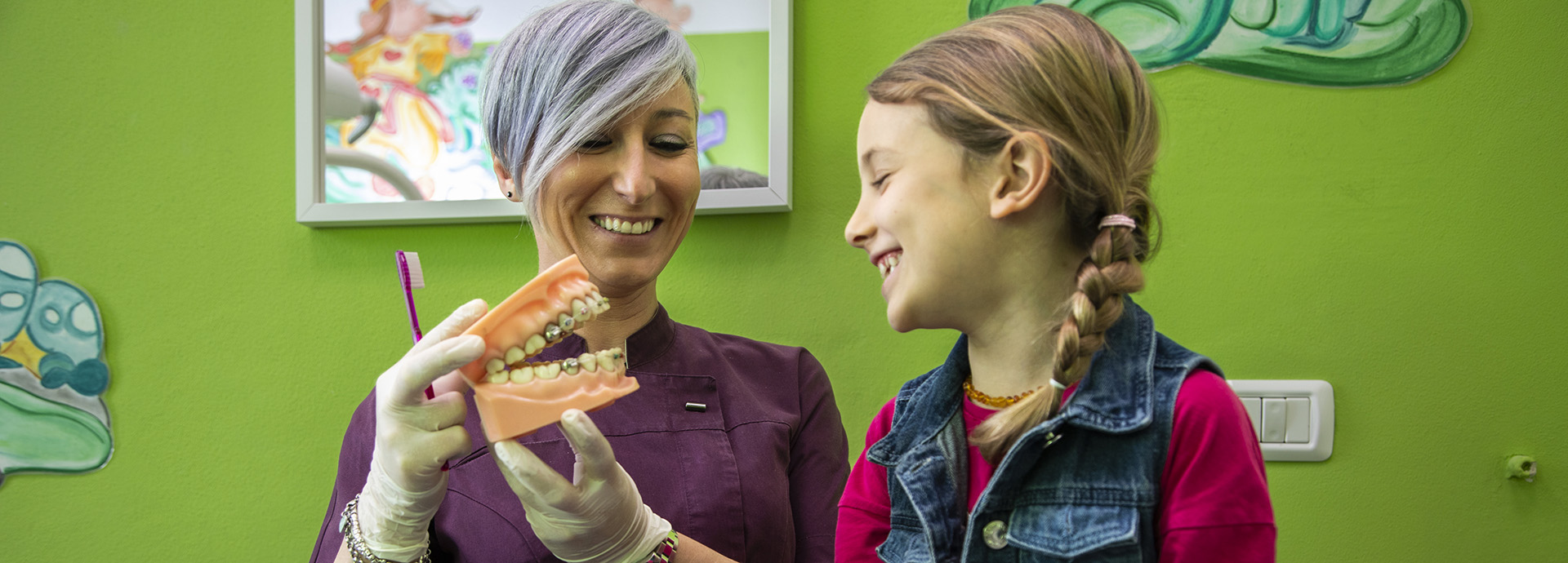 Dentista pediatrica dello studio Ferman for Kids che sorride e interagisce in modo giocoso con una piccola paziente durante la visita