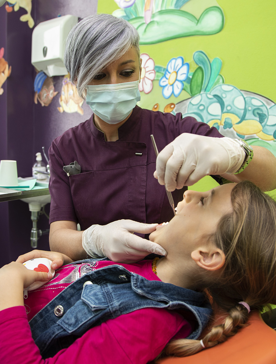 Specialista in odontoiatria pediatrica che controlla la bocca di una bambina